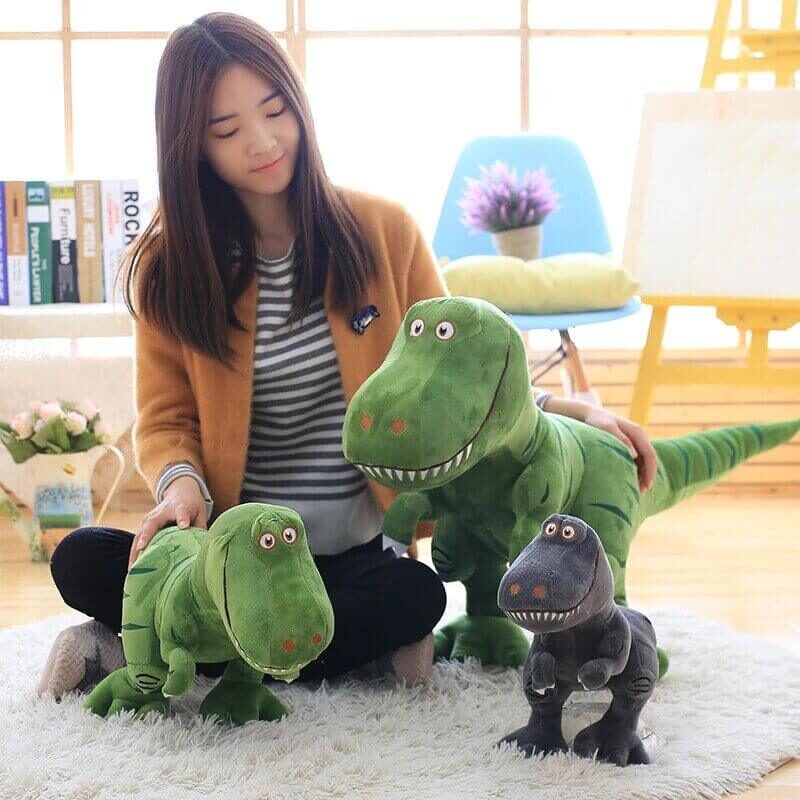 Brown haired girl playing with tyrannosaurus rex plushie family