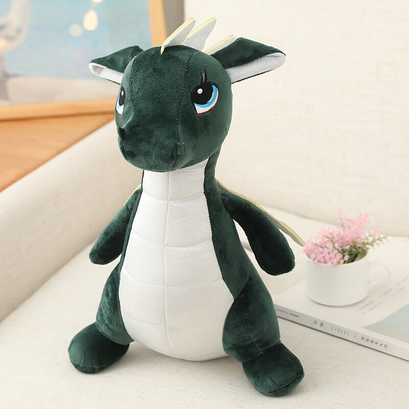 Green dragon with white under belly with eyes looking upwards sat on a white couch