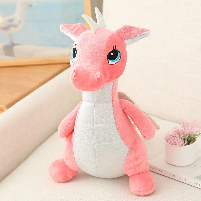 Pink dragon with white under belly with eyes looking upwards sat on a white couch