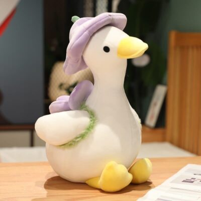 White goose with purple flower hat and purple flower backpack called Purple Goose sitting on a table