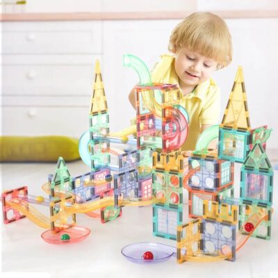 Magnetic marble run with a happy little boy building his marble run track