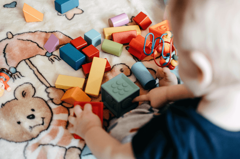 Toddler playing with toy blocks